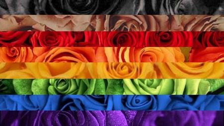 philly rainbow flag edit with stripes being replaced with images of flowers, primarily roses, corresponding to each stripe and its color. Color stripes are: black, brown, red, orange, yellow, green, blue, and purple. 
