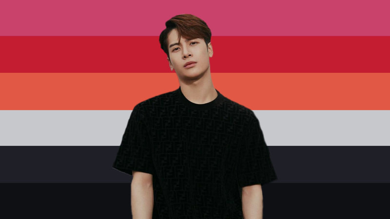 Flag with 6 horizontal stripes that are pink, red, orange, dusty white, grey, and black. Jackson Wang is on the flag with brown hair and a black t-shirt.